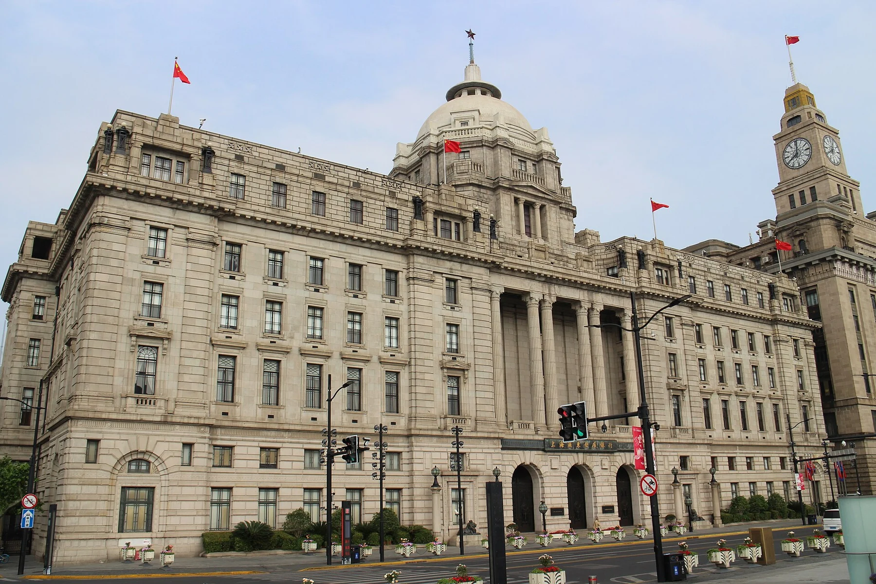 The domed banking building beside the taller Customs House clock tower, with the road in front.