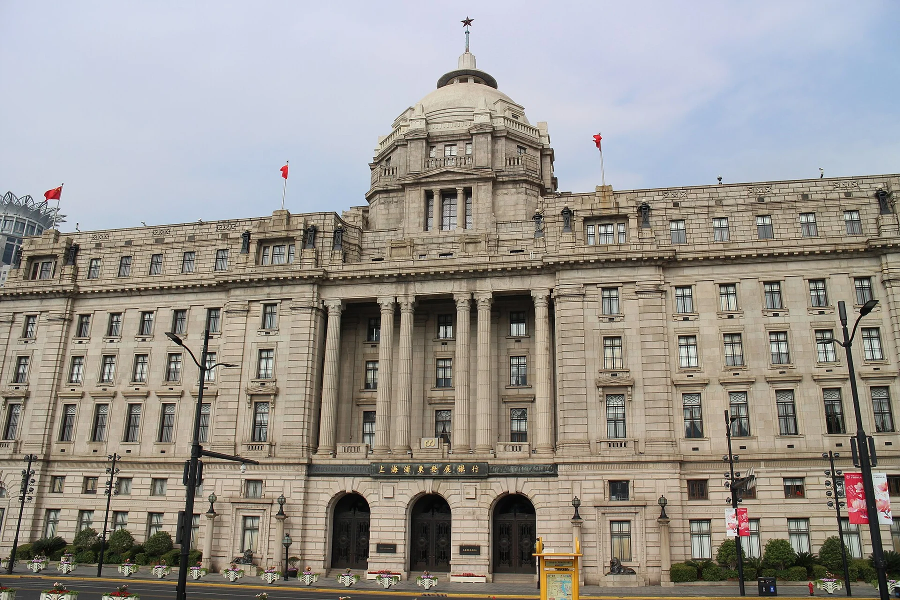 A broad stone banking facade with tall columns and a central dome.