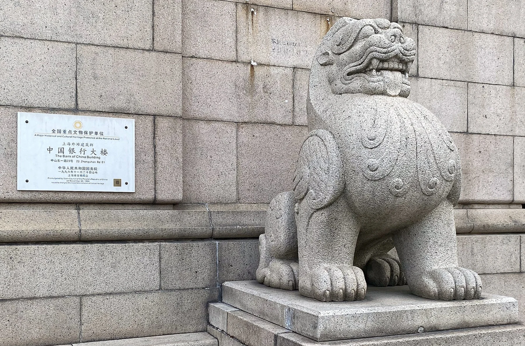A carved stone lion next to the building’s heritage-protection plaque.