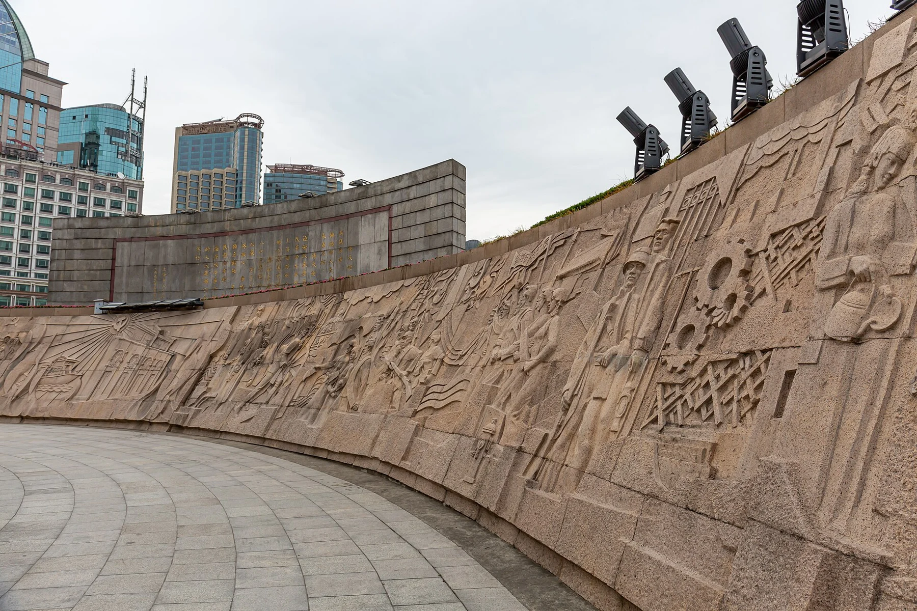 A long curved relief wall filled with carved figures and scenes.