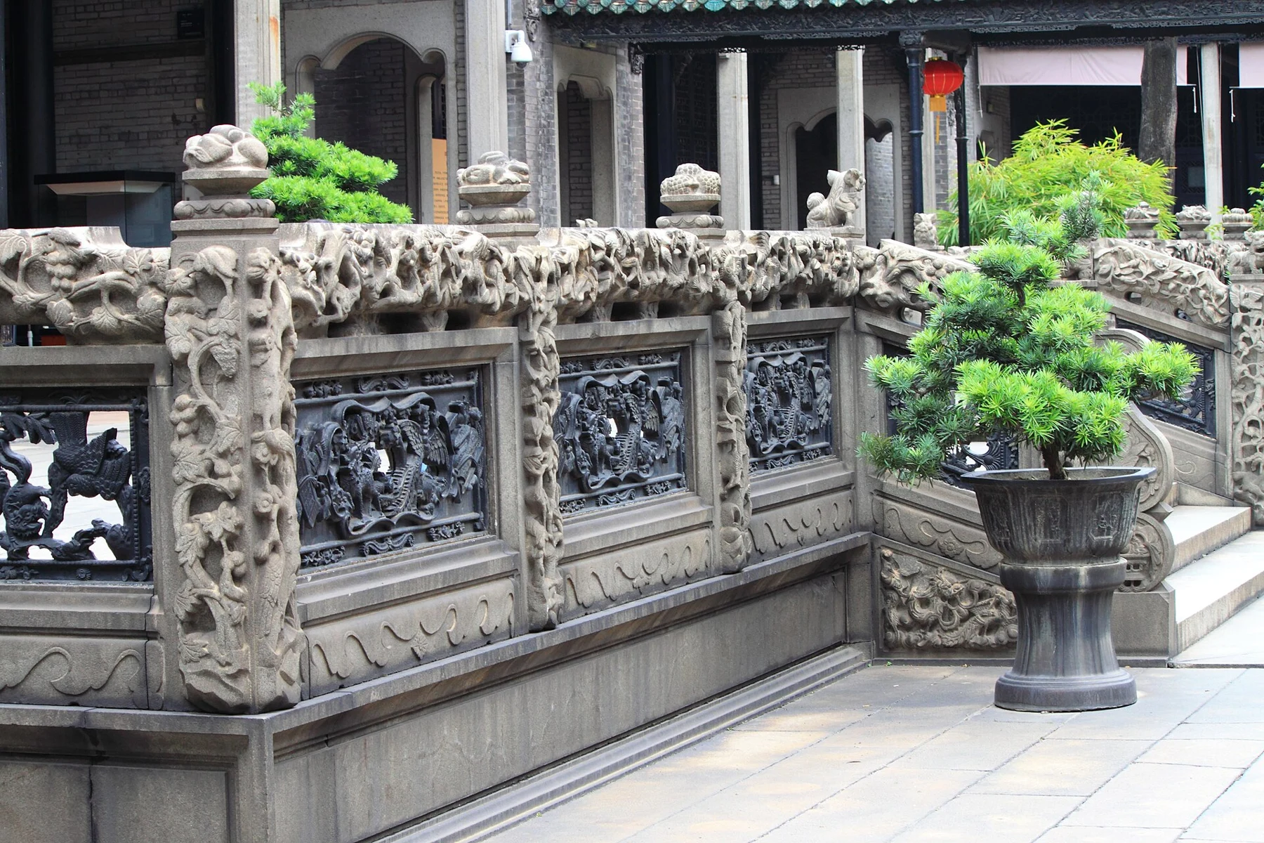 Dark openwork railing panels framed by carved pale stone.