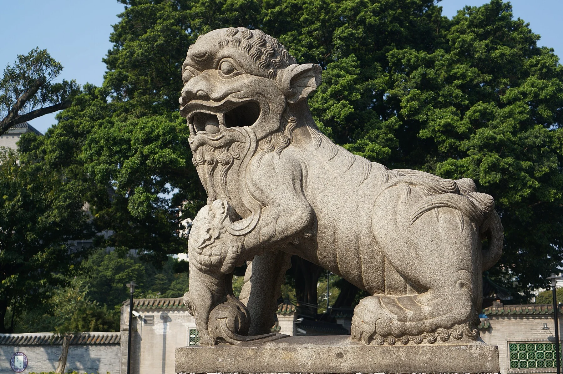 Stone lion on a plinth outside Chen Clan Ancestral Hall.