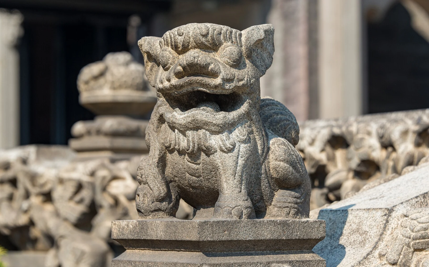 Smaller carved stone guardian beside an interior platform.