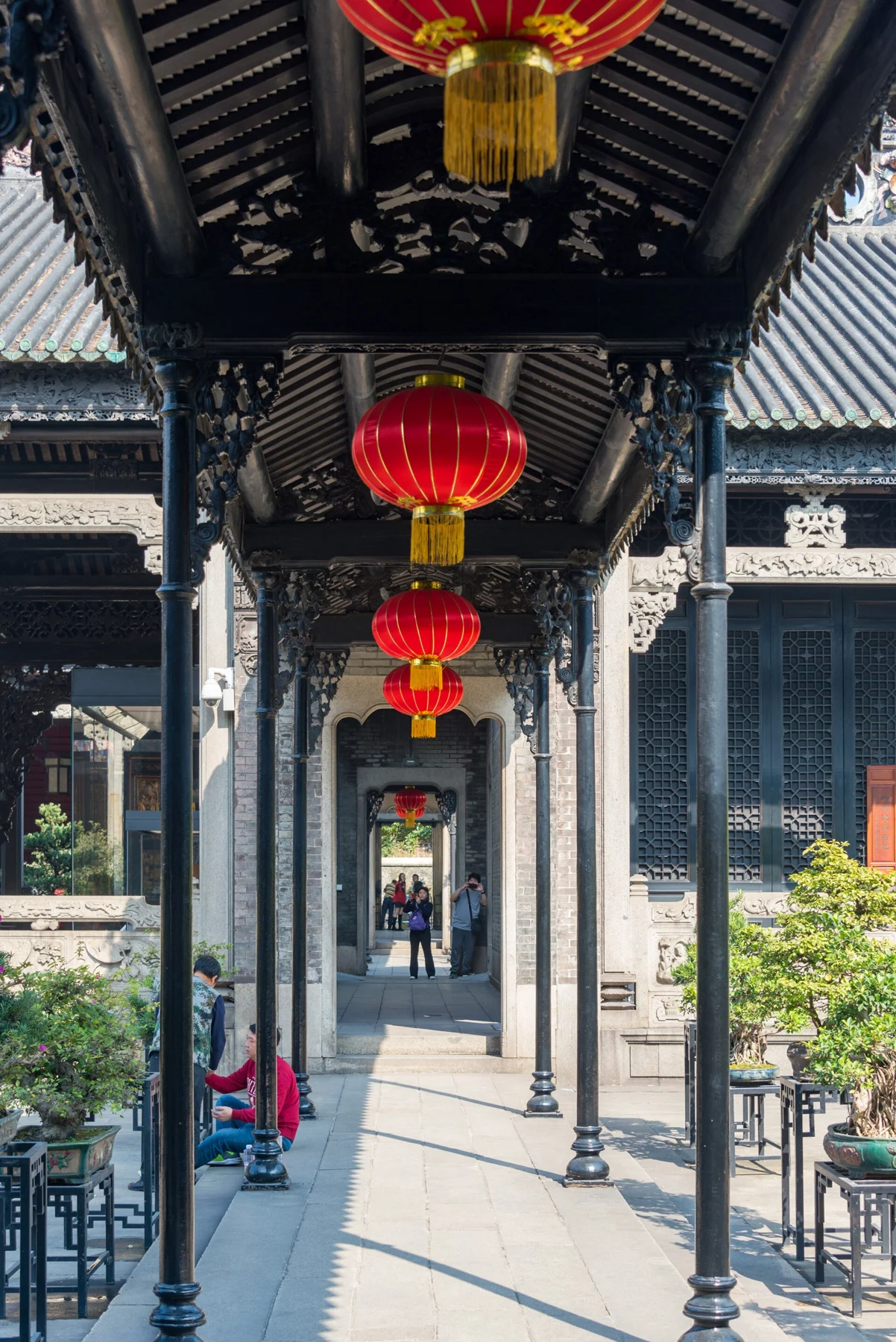 Covered corridor with dark columns and hanging red lanterns.