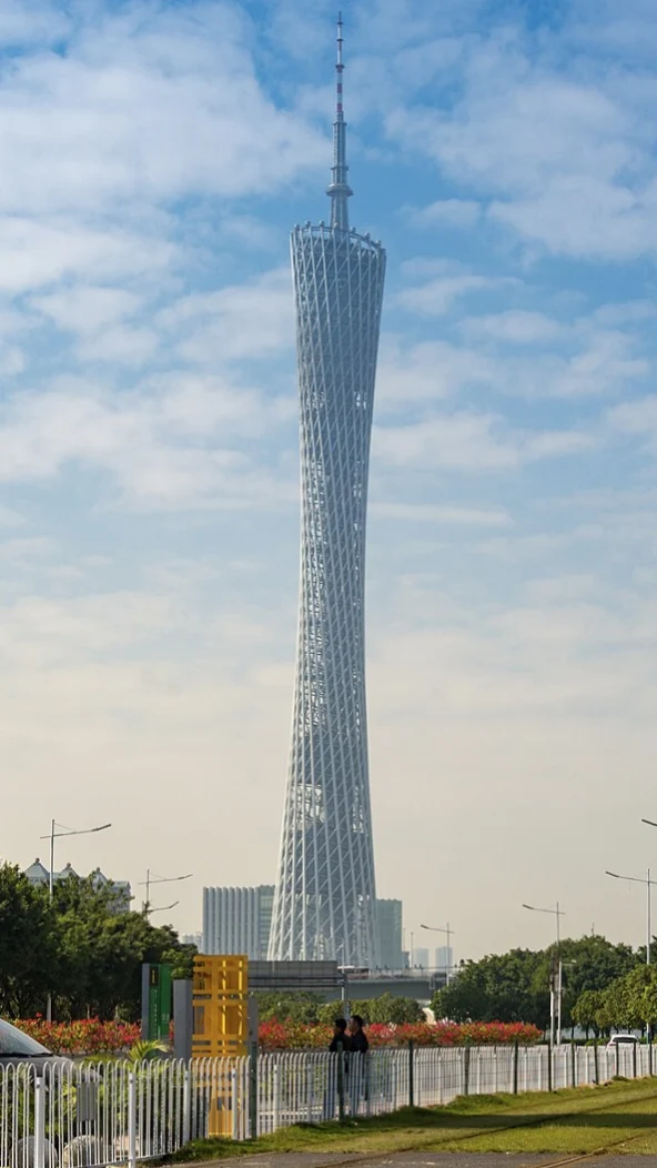 Daylight exterior showing the tower’s twisting lattice and long antenna.