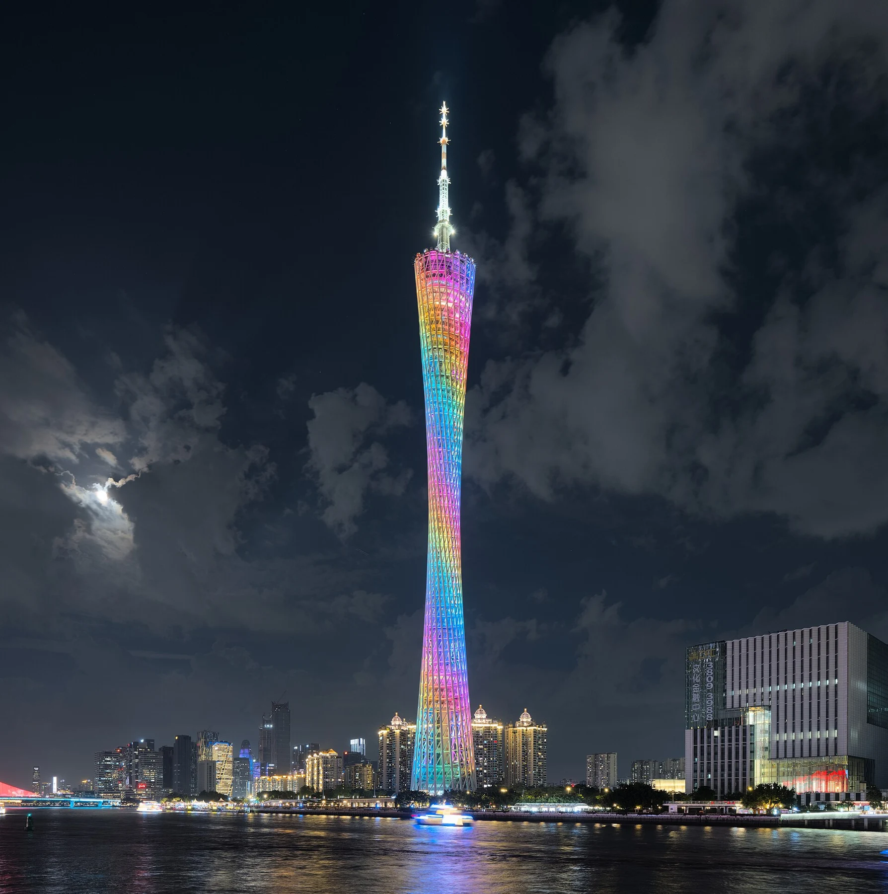 Canton Tower illuminated in several colours above the river.