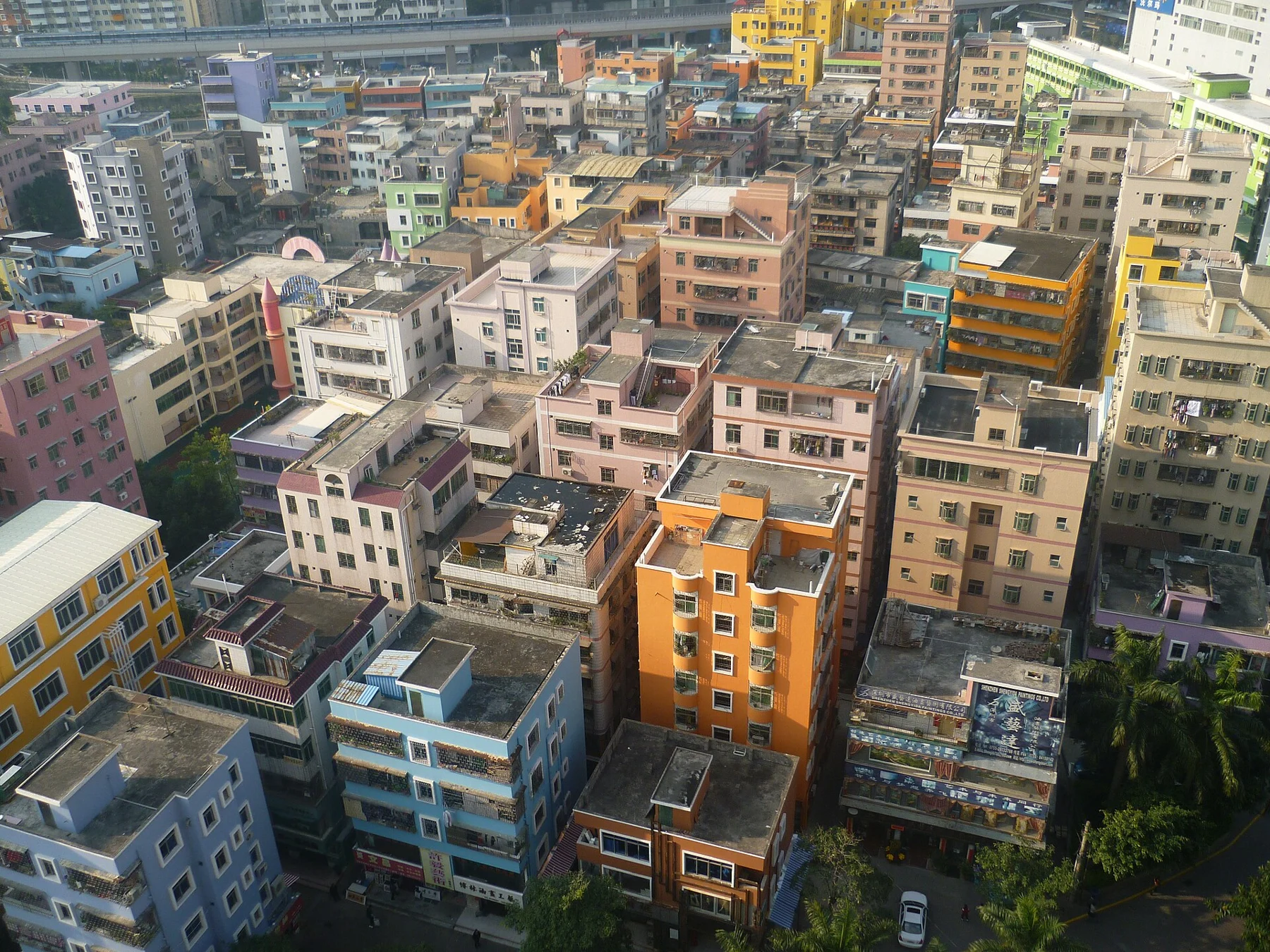 Dense coloured buildings with small lanes and rooftops, seen from an elevated viewpoint