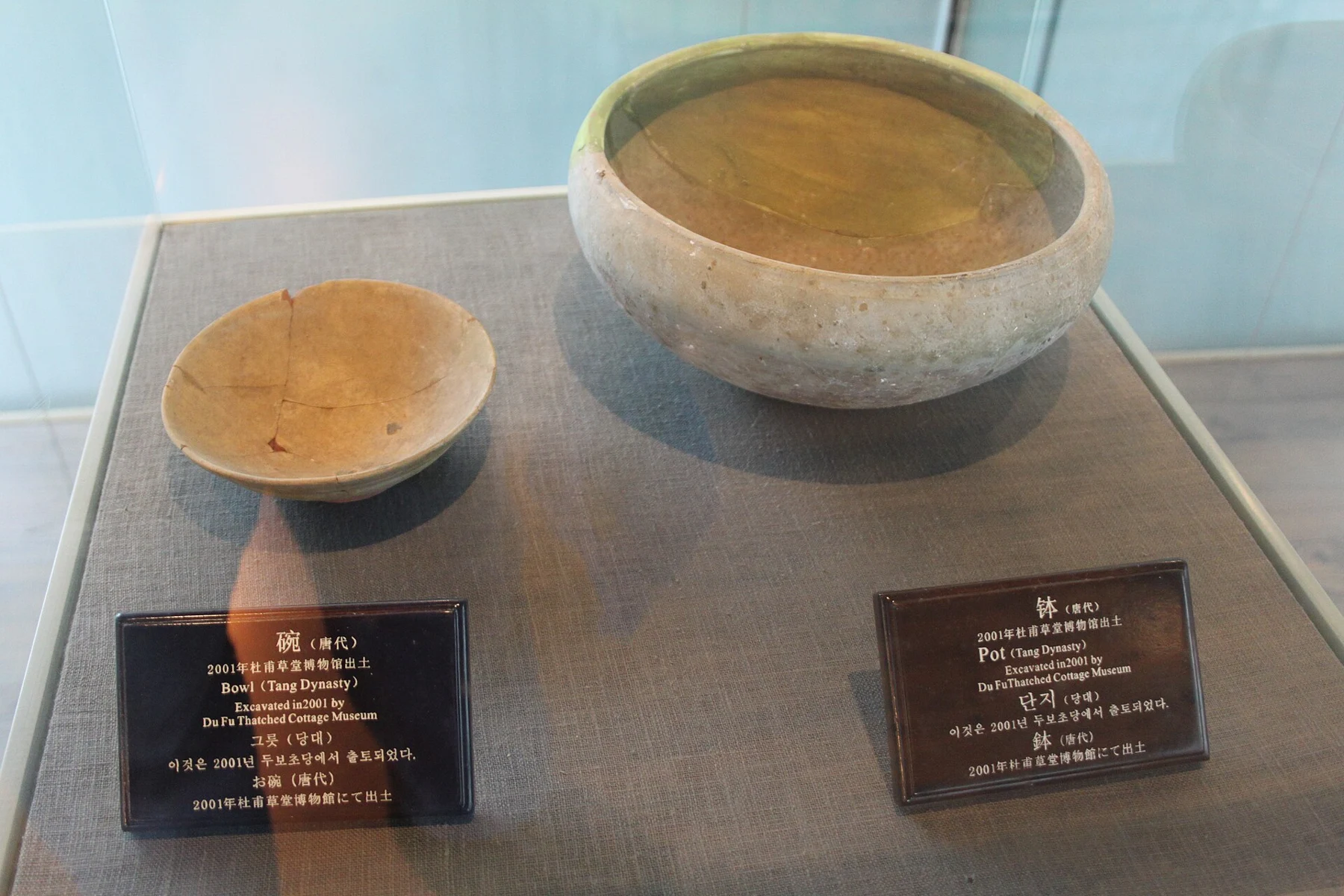 A bowl and a larger vessel labelled Tang-period excavation finds, photographed in 2010.