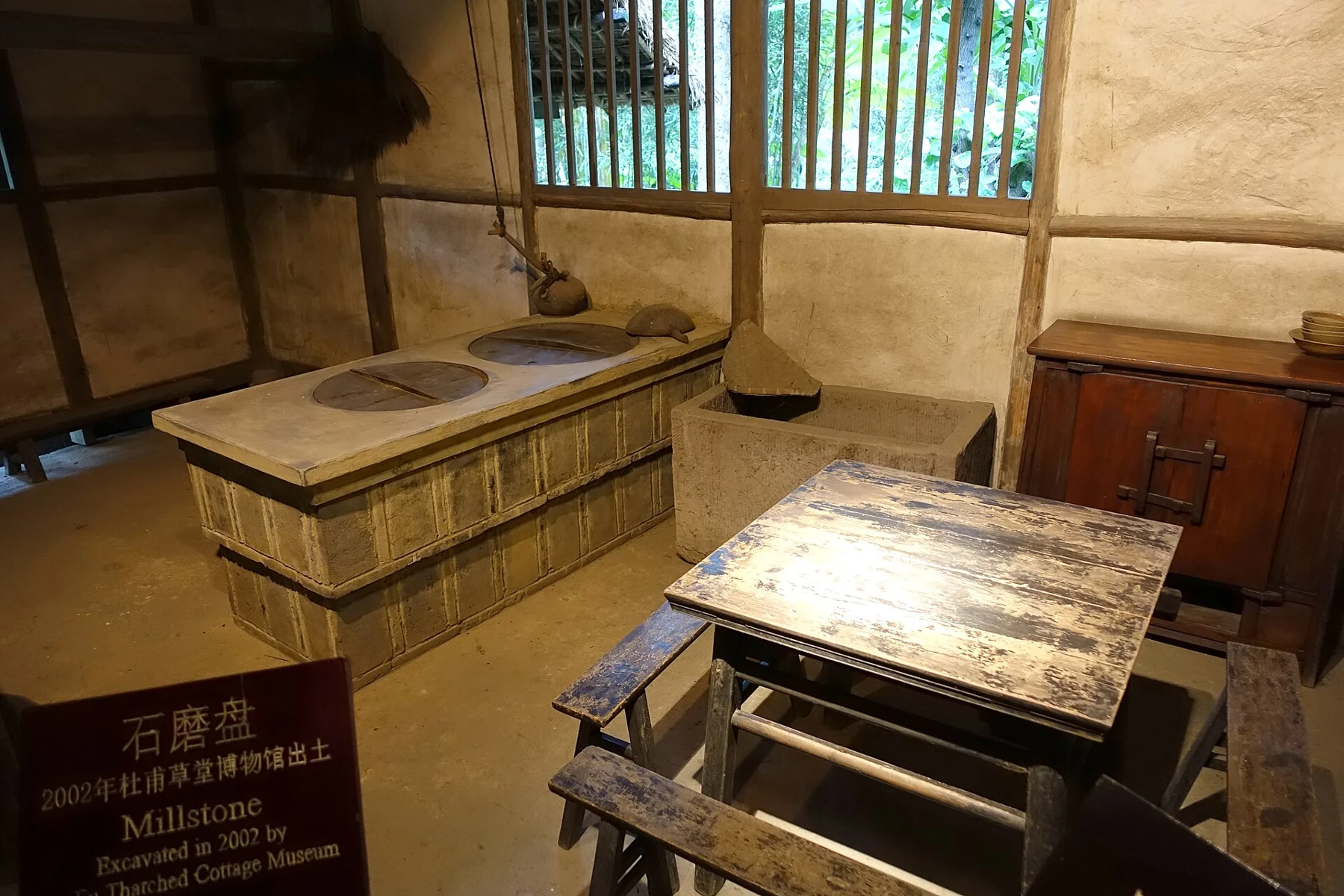 A cooking-area display with a built stove and work table inside the reconstructed cottage, photographed in 2015.