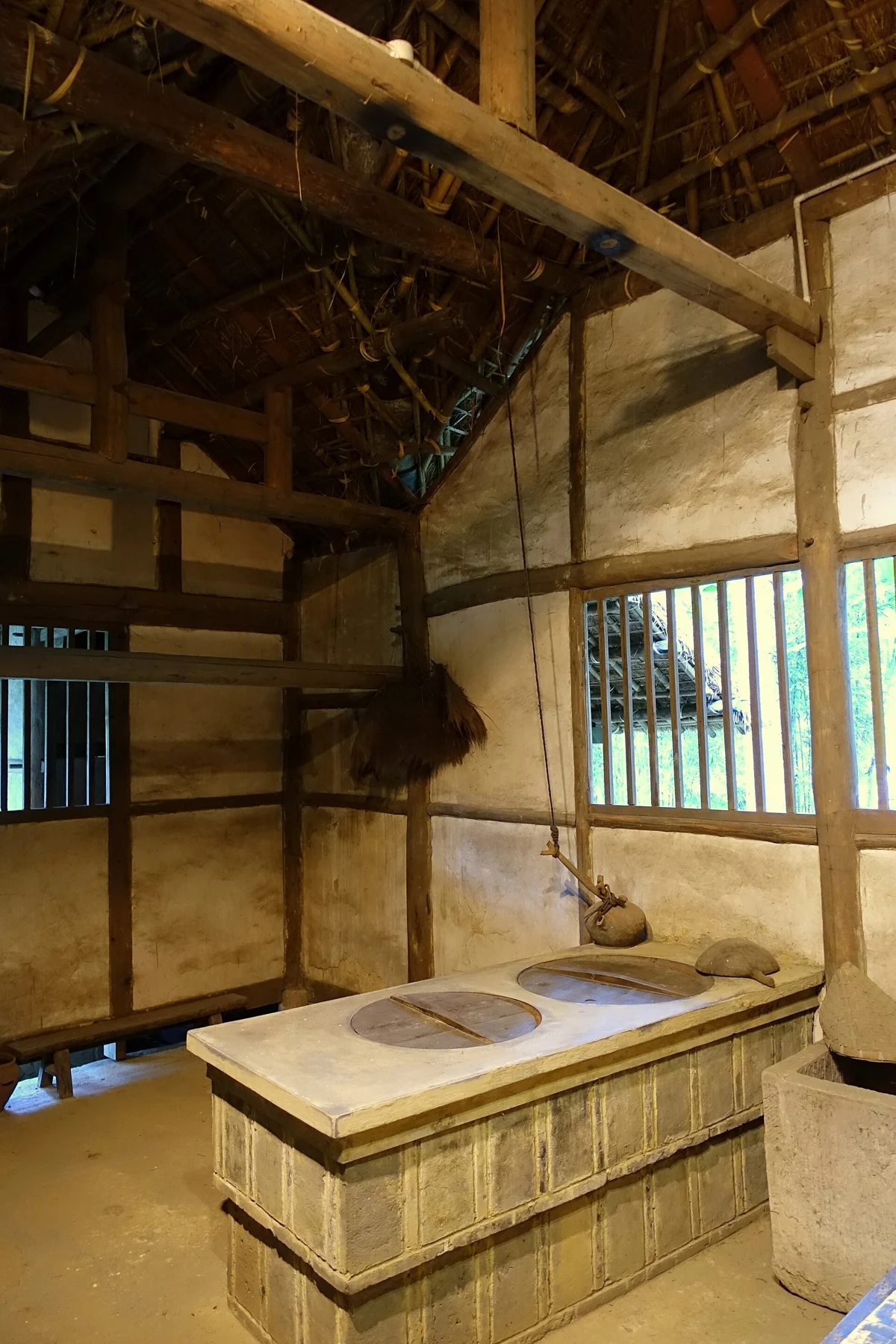 The stove, timber frame and underside of the thatched roof in the reconstruction, photographed in 2015.