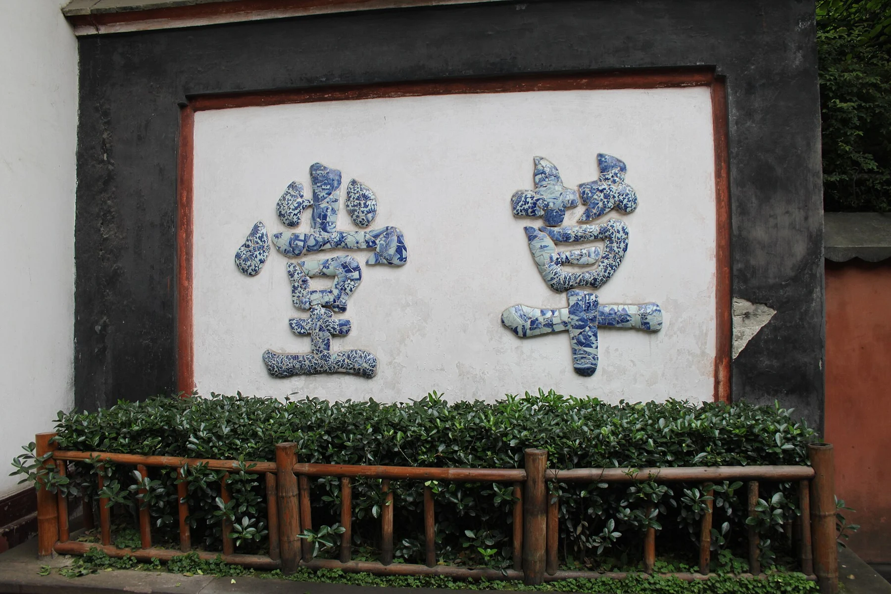 The broken-porcelain 草堂 characters on a screen wall, photographed in 2010.