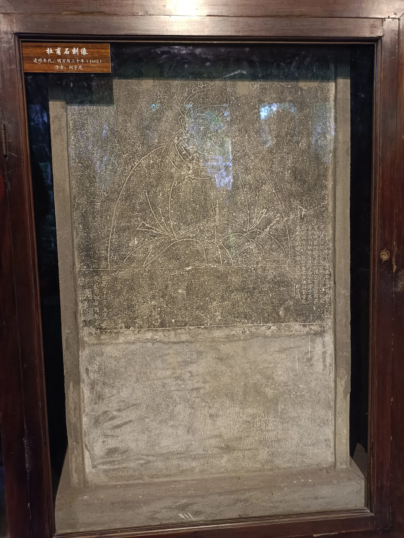 A stone portrait whose label names He Yudu and 1602, photographed in April 2023.