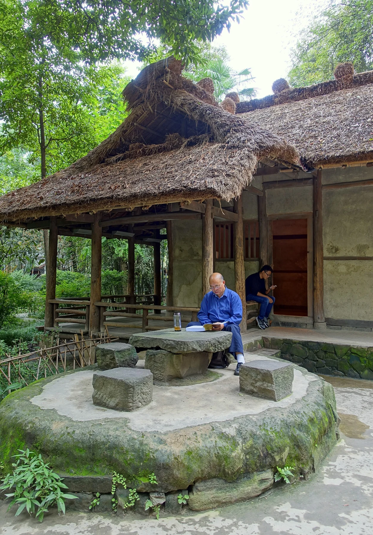 A stone table and seats beside the reconstructed cottage, photographed in 2015.