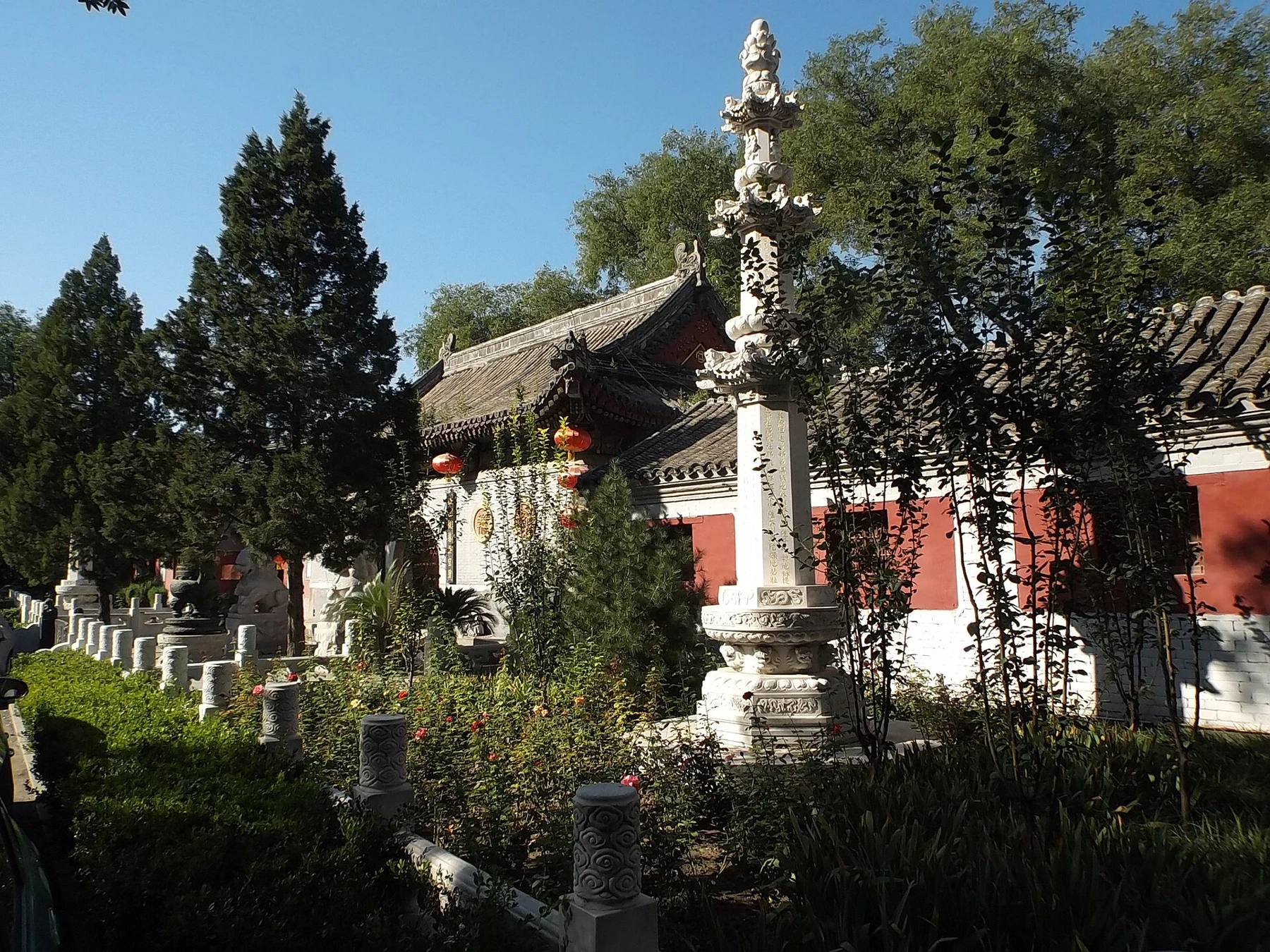 Stone monuments and red-walled buildings in a Guanghua Temple courtyard