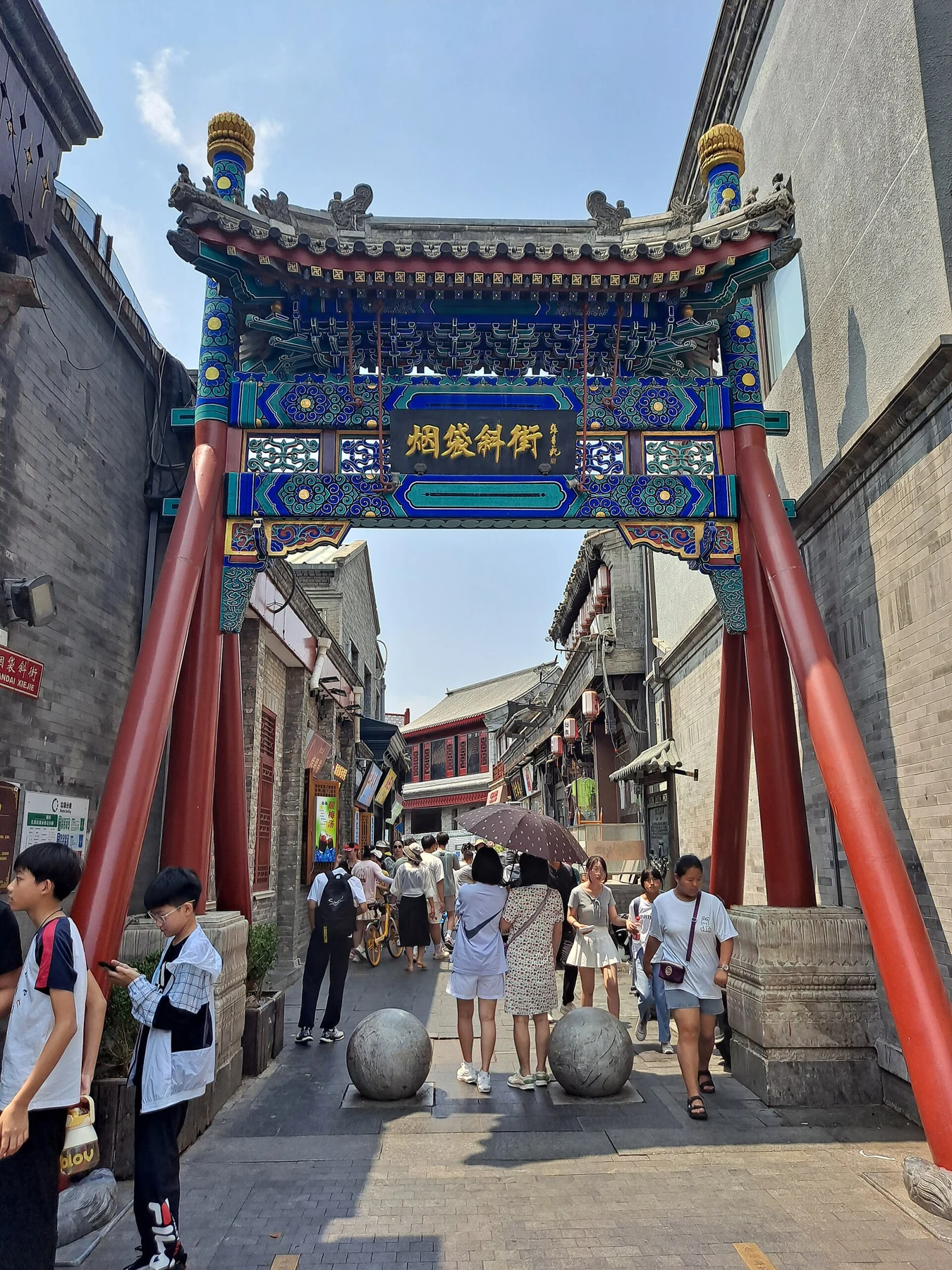 An ornamental archway and the narrow commercial lane at Yandai Xiejie