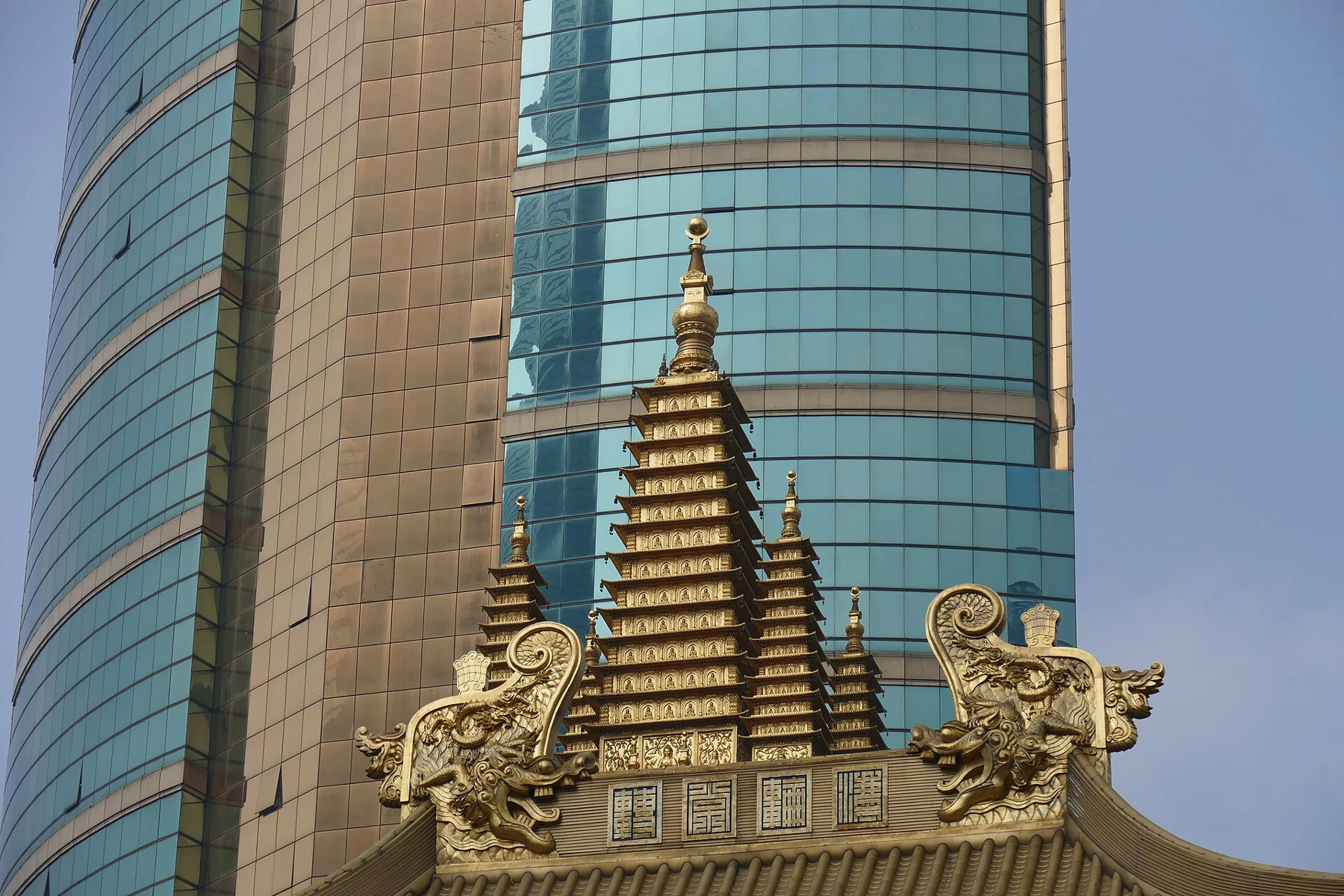 Clustered gilded pinnacles above a temple roof edge.