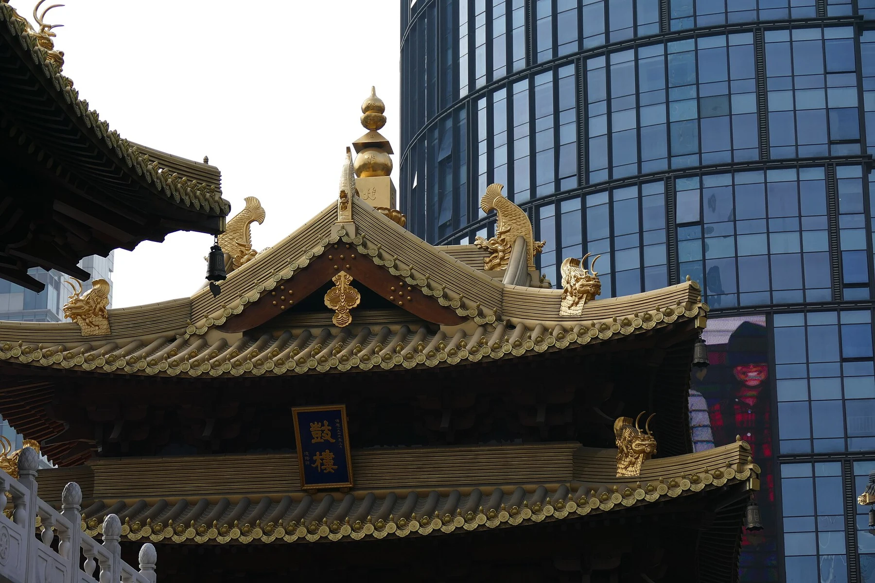 Drum-tower plaque below two roof levels with gilded ridge forms.