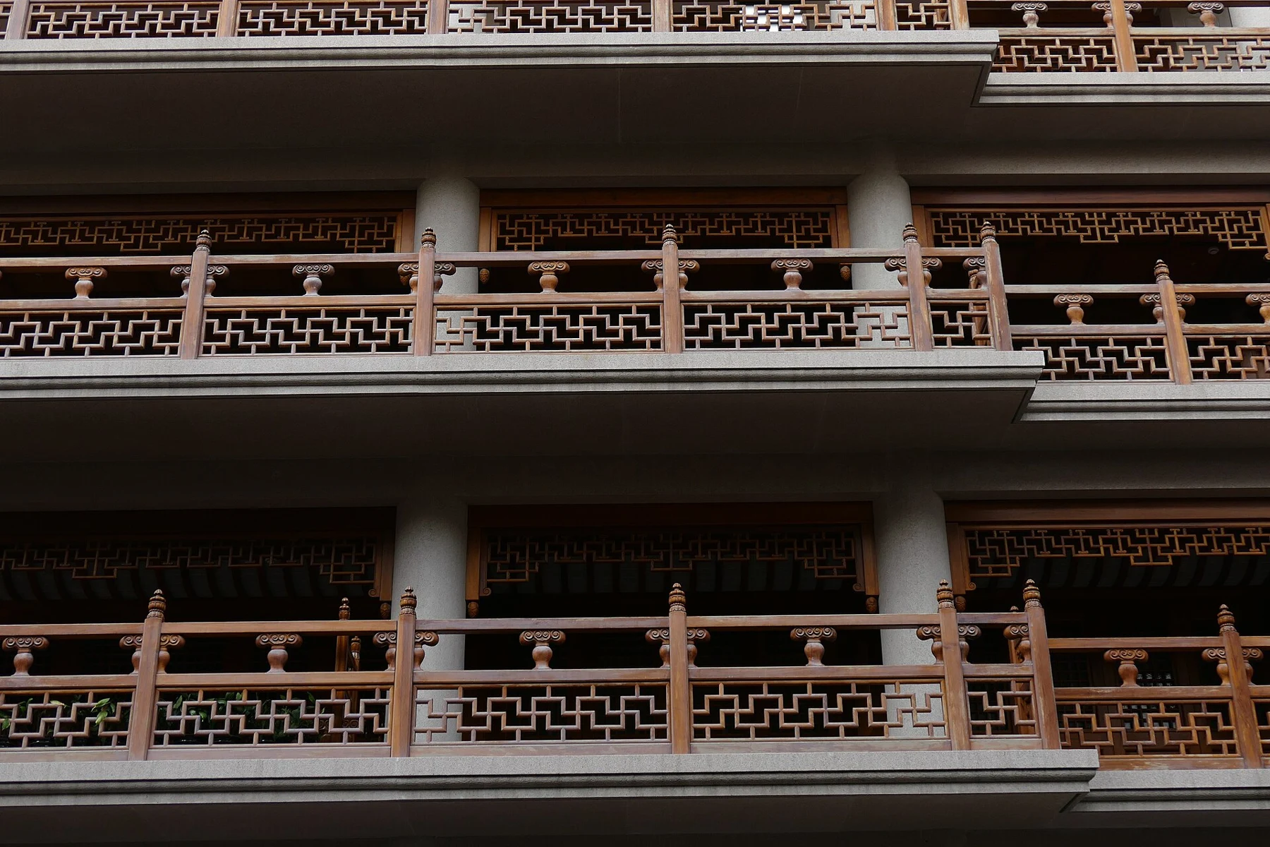 Three levels of patterned wooden railings and vertical columns.