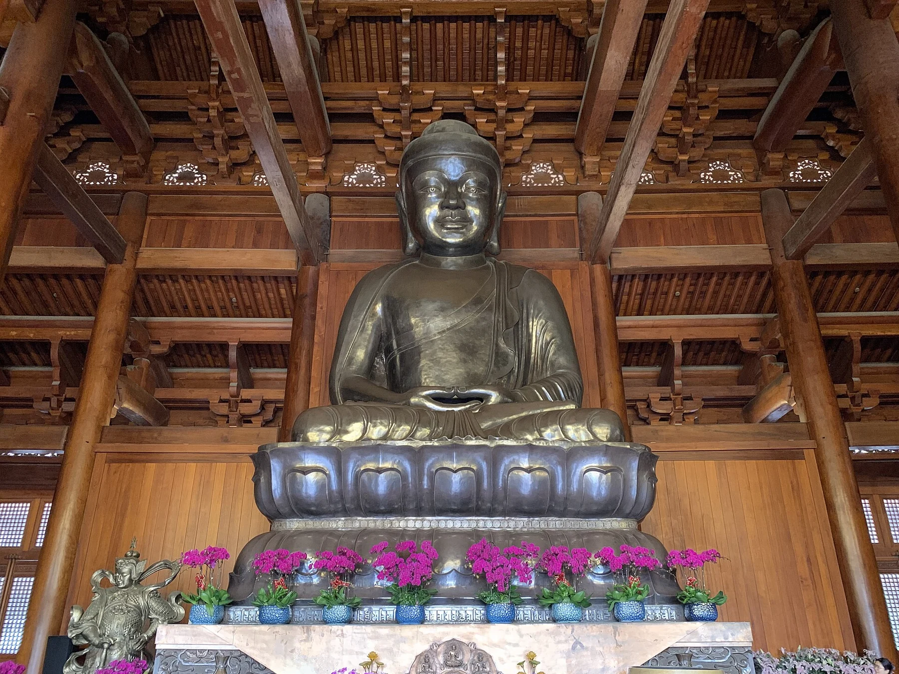 A seated Buddha beneath the visible overhead timber structure.