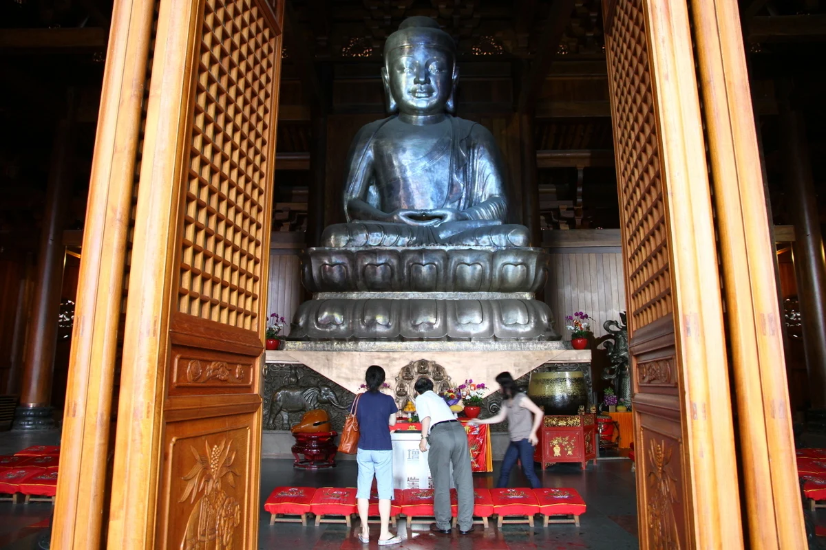 Silver-coloured seated figure above a lotus base inside the main hall.