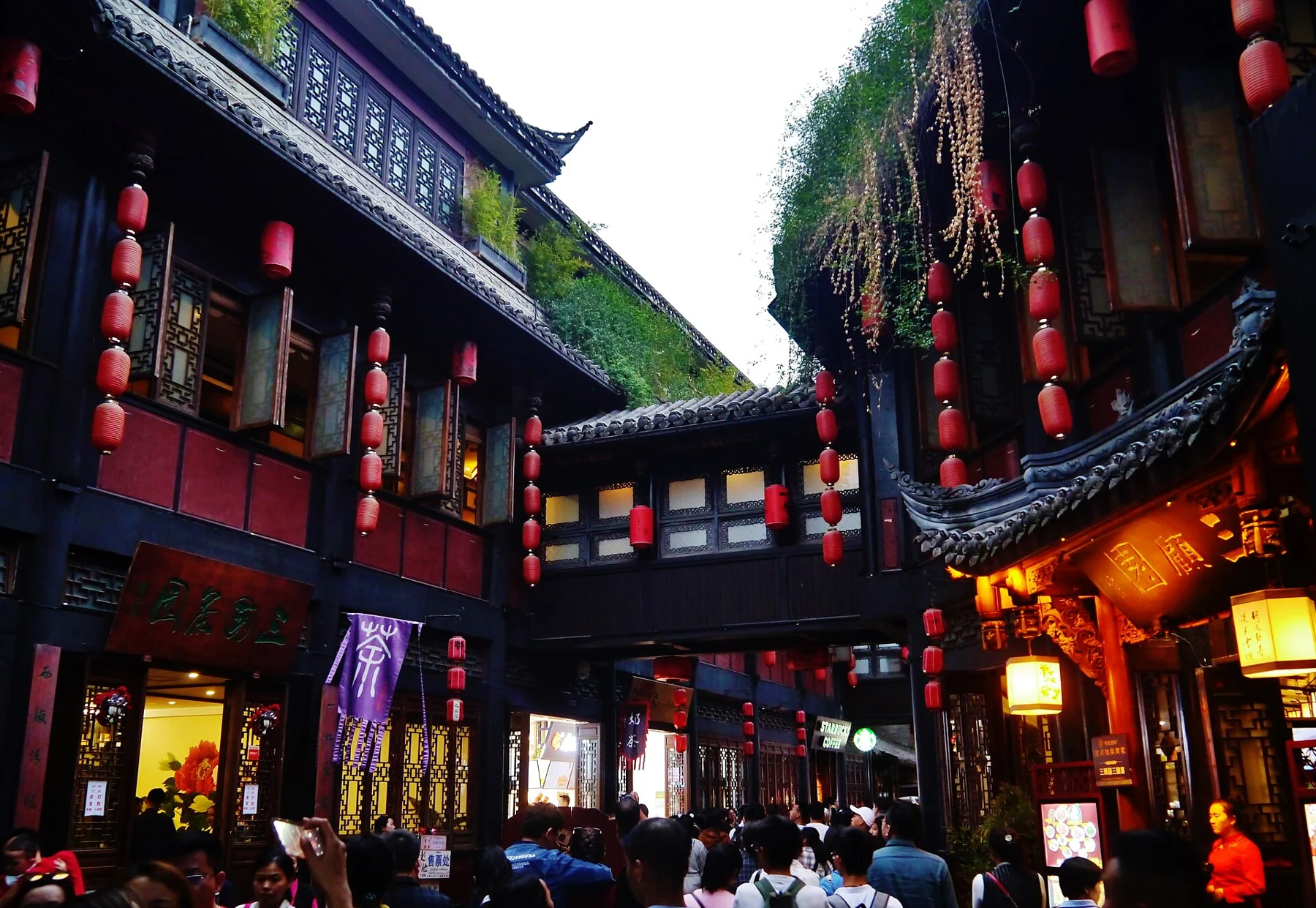 Two-storey timber fronts with red lanterns and an overhead connection