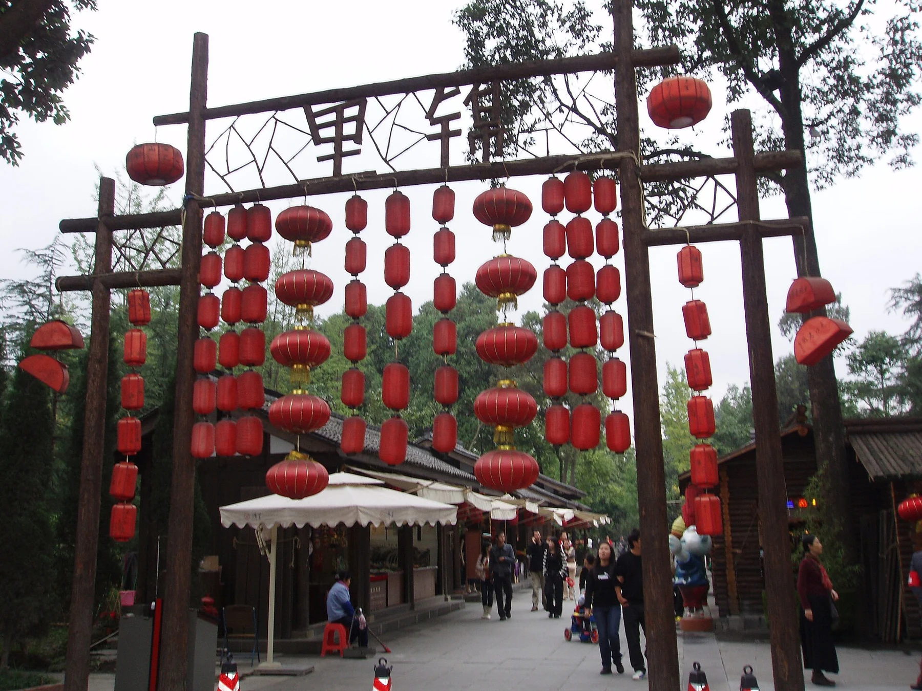 Jinli entrance with a high timber frame and rows of red lanterns