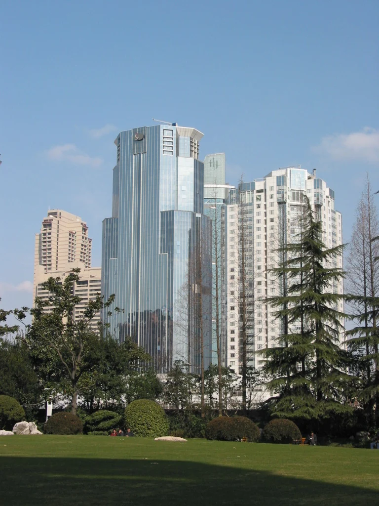 An earlier view across a green park lawn towards city buildings.