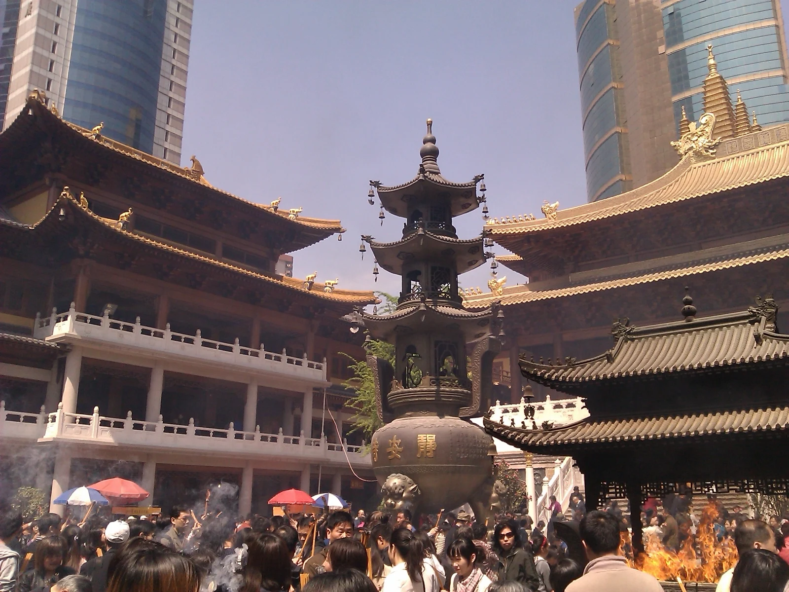 Visitors in the temple courtyard between layered roofs.
