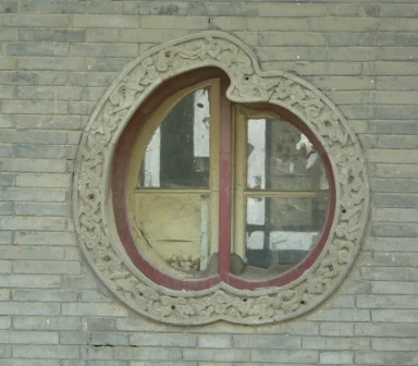 A shaped brick window in the Rear Building, framing a view beyond.