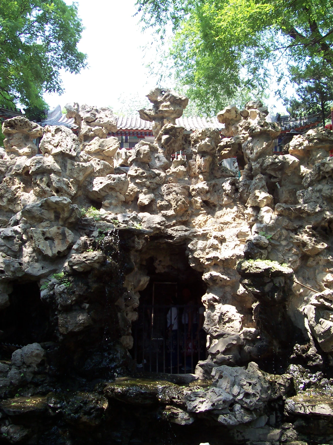 Artificial garden rockwork and a dark cave opening.