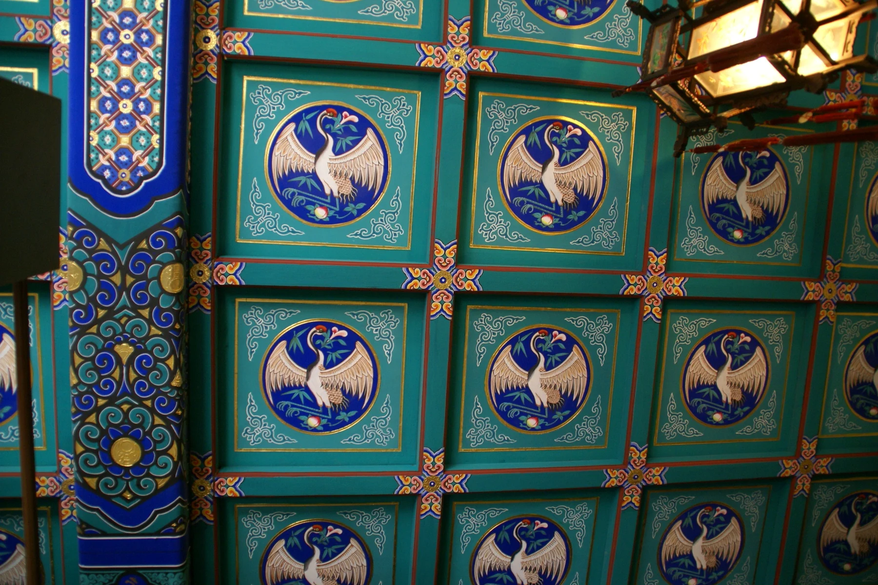 Blue-green ceiling panels with painted birds in circular medallions.