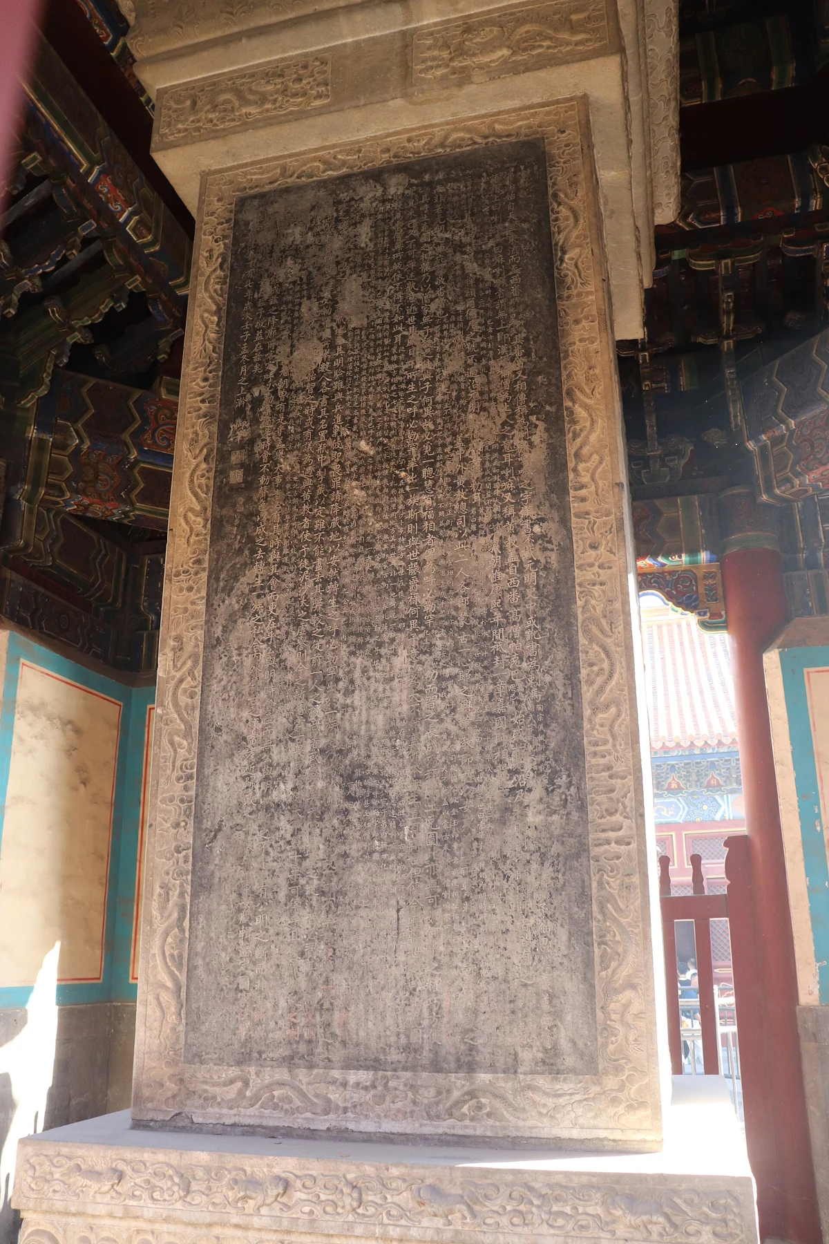 The inscribed stone Lama Shuo stele seen within an open pavilion.