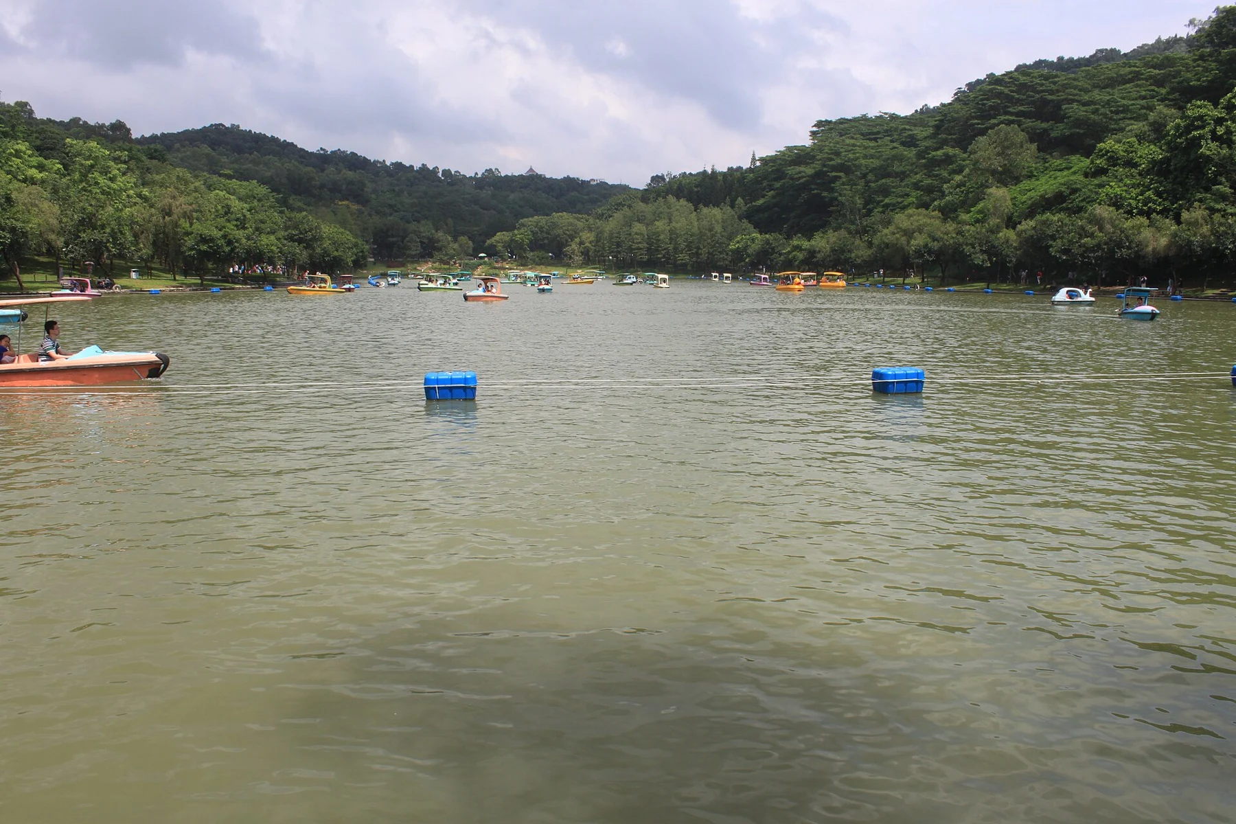 Park lake, wooded slopes and small boats photographed in 2016