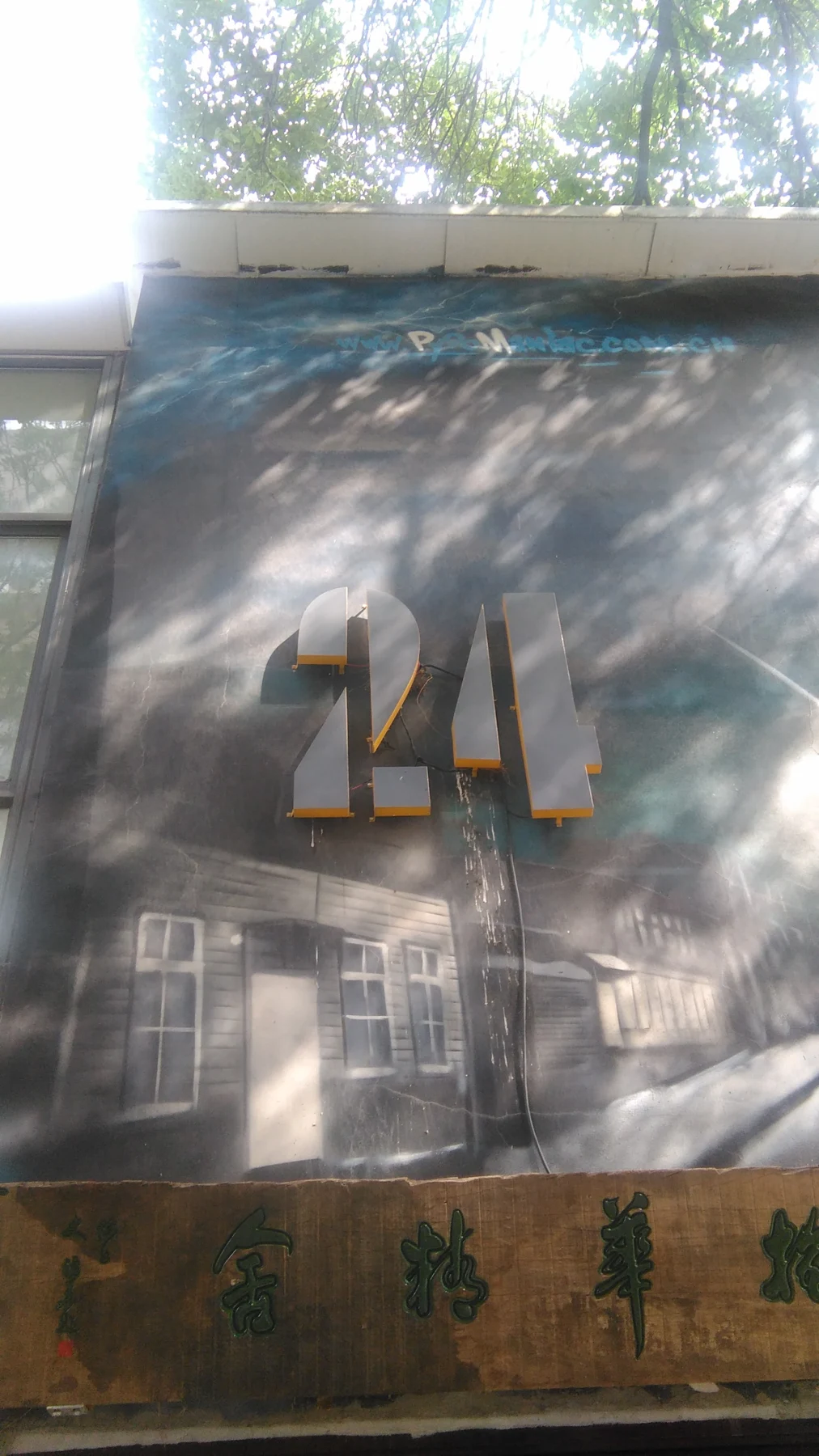 The raised number 24 on a shaded pale wall.