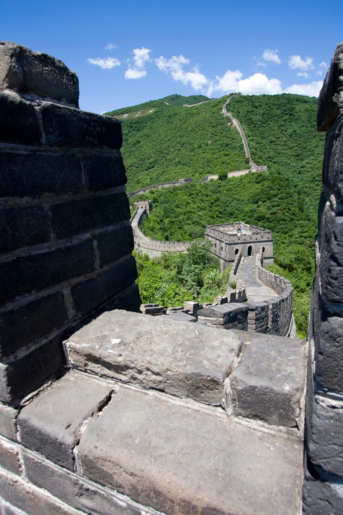 The Mutianyu wall and watchtowers in green wooded hills.