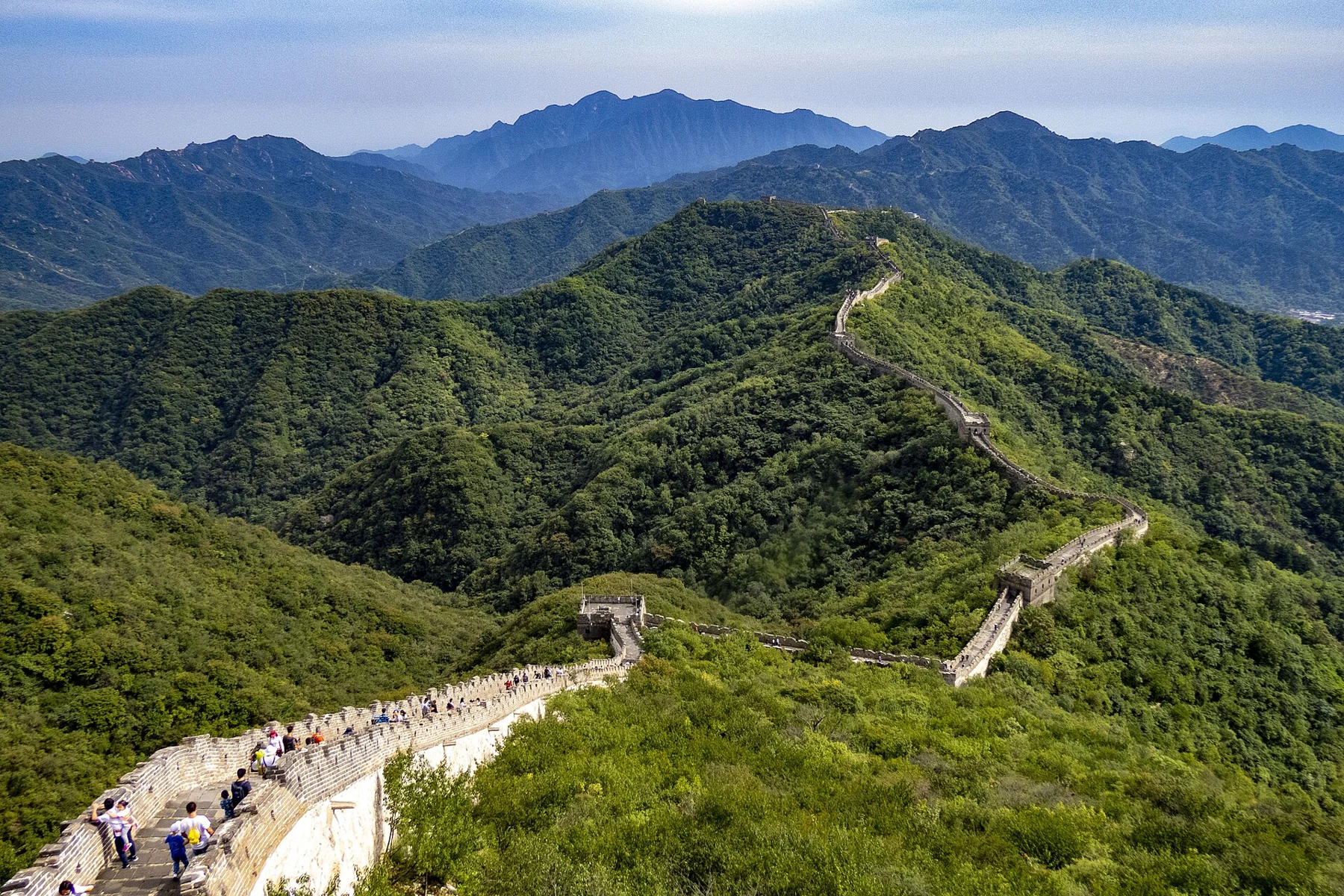 The wall descending along a mountain ridge below a high viewpoint at Mutianyu.