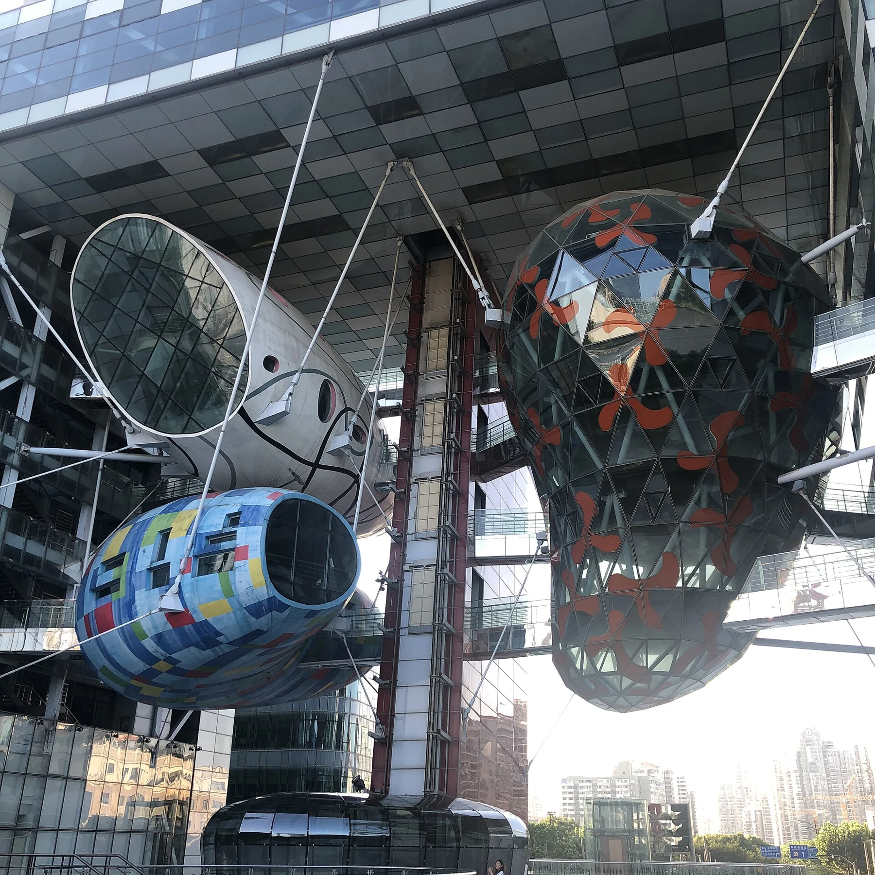 Large colourful rounded spaces suspended in a steel framework, with an oval connecting bridge.