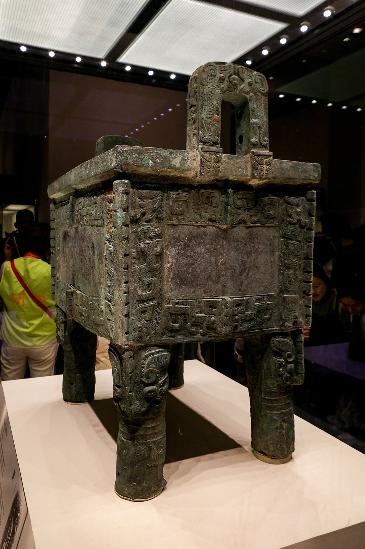 A closer angled view of the Shang bronze cauldron and its patterned surfaces.