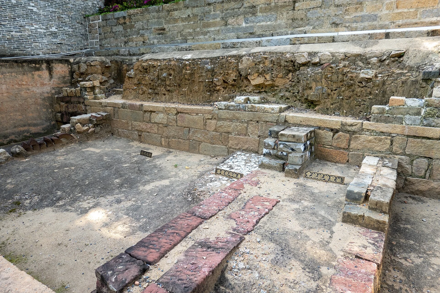 Excavated stone and earth layers with small Chinese interpretation labels