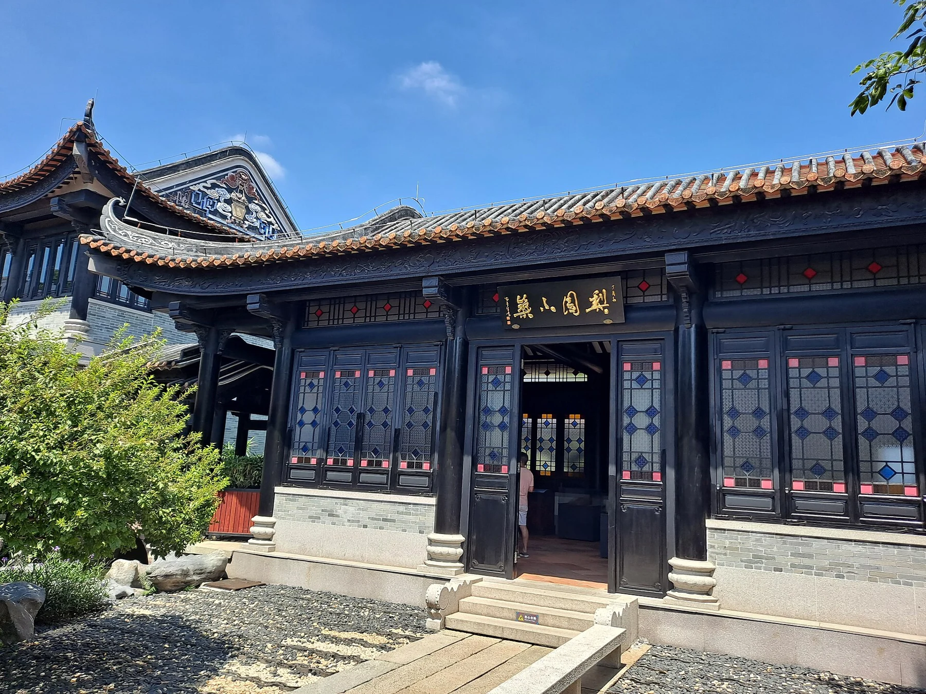 Liyuan Xiaozhu courtyard building, its Chinese name plaque and coloured-glass windows