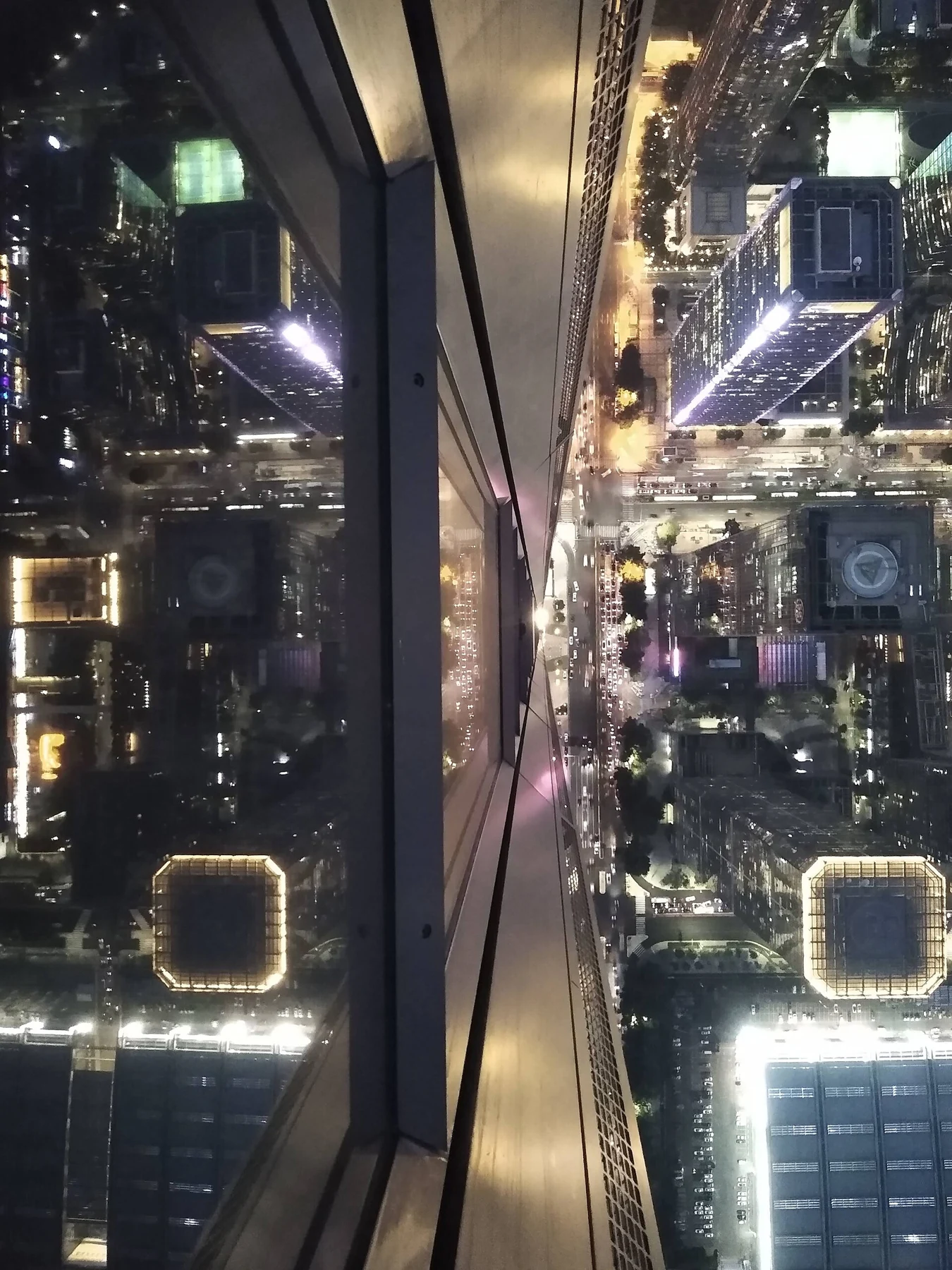 Night streets appear through the observatory glazing and its reflections.