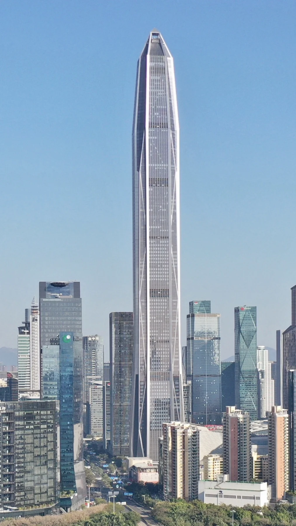 The slender tapering Ping An tower stands against a clear blue sky.