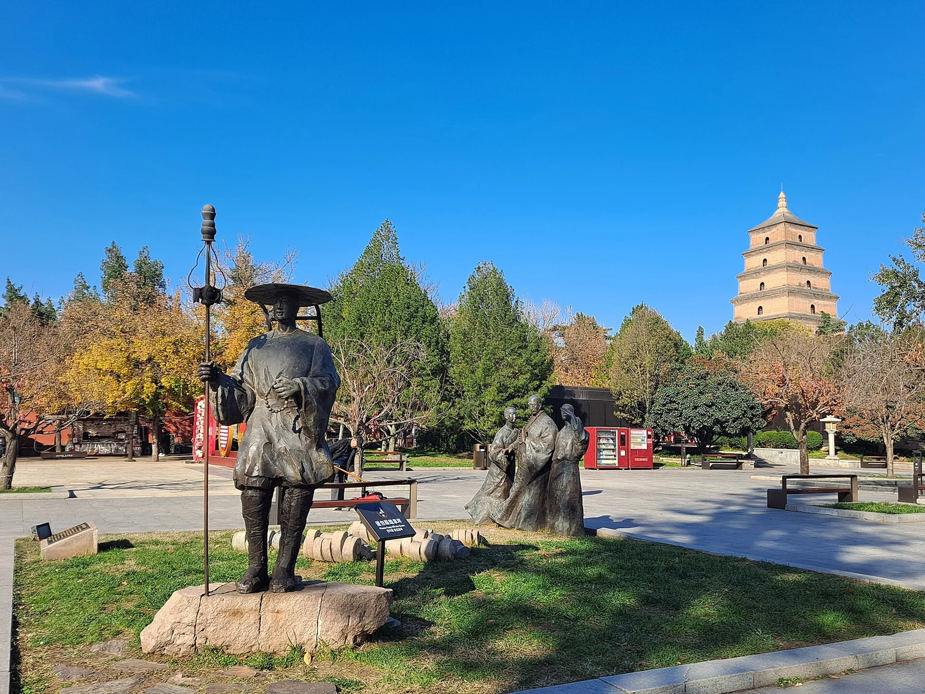 Modern group sculpture in a landscaped public park with the pagoda in the distance.