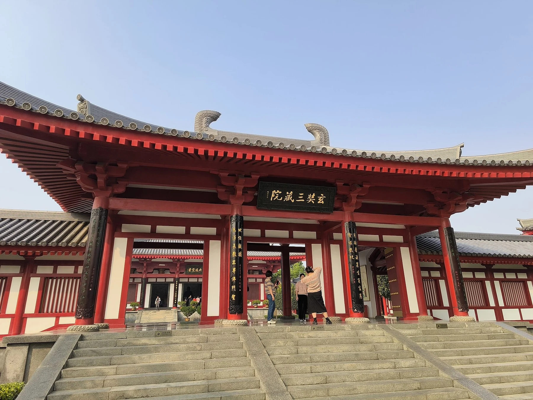 Red gateway bearing the 玄奘三藏院 plaque, with the memorial hall beyond.