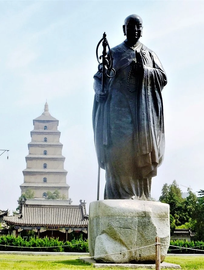 Standing bronze Xuanzang statue with the pagoda beyond.
