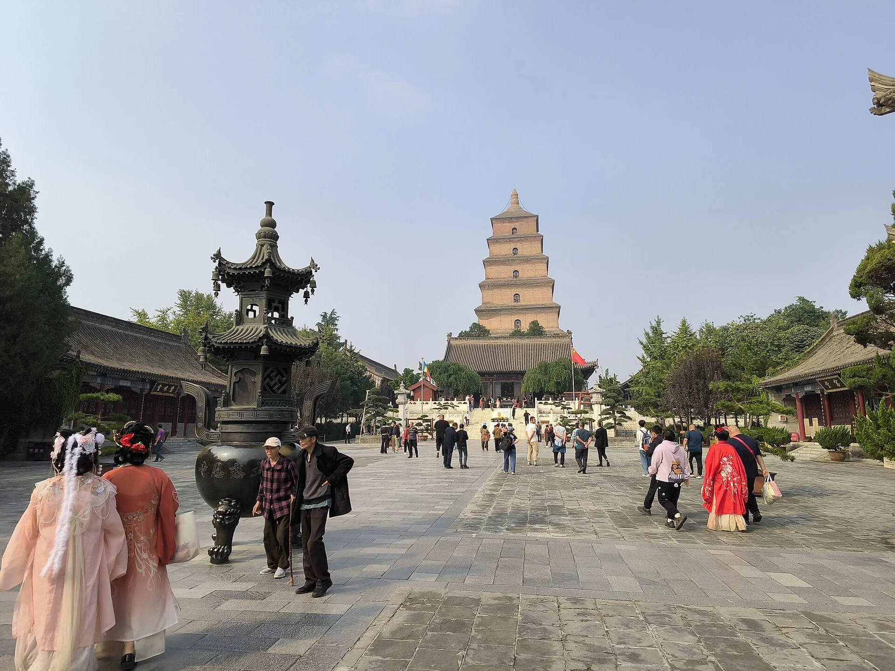 Visitors and a stone incense structure on the temple’s courtyard axis towards the pagoda.