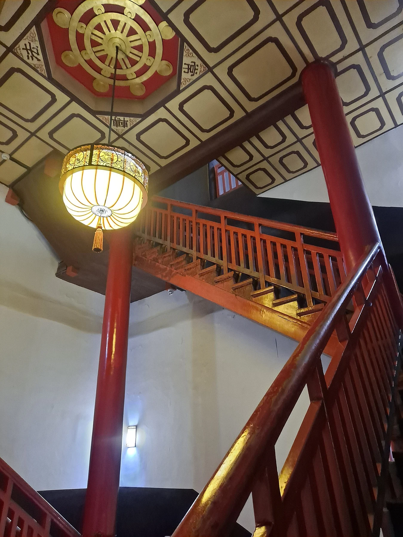 Red-railed staircase and decorated ceiling inside the pagoda.