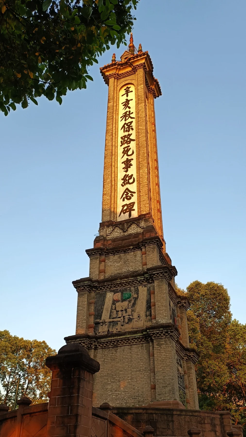 A long panel of calligraphy on one face of the memorial tower.