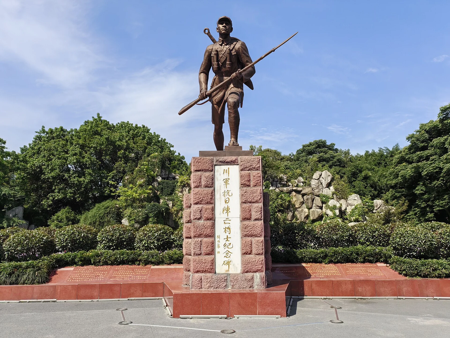 A bronze soldier holding a rifle above a stone pedestal with Sichuan Army memorial lettering.