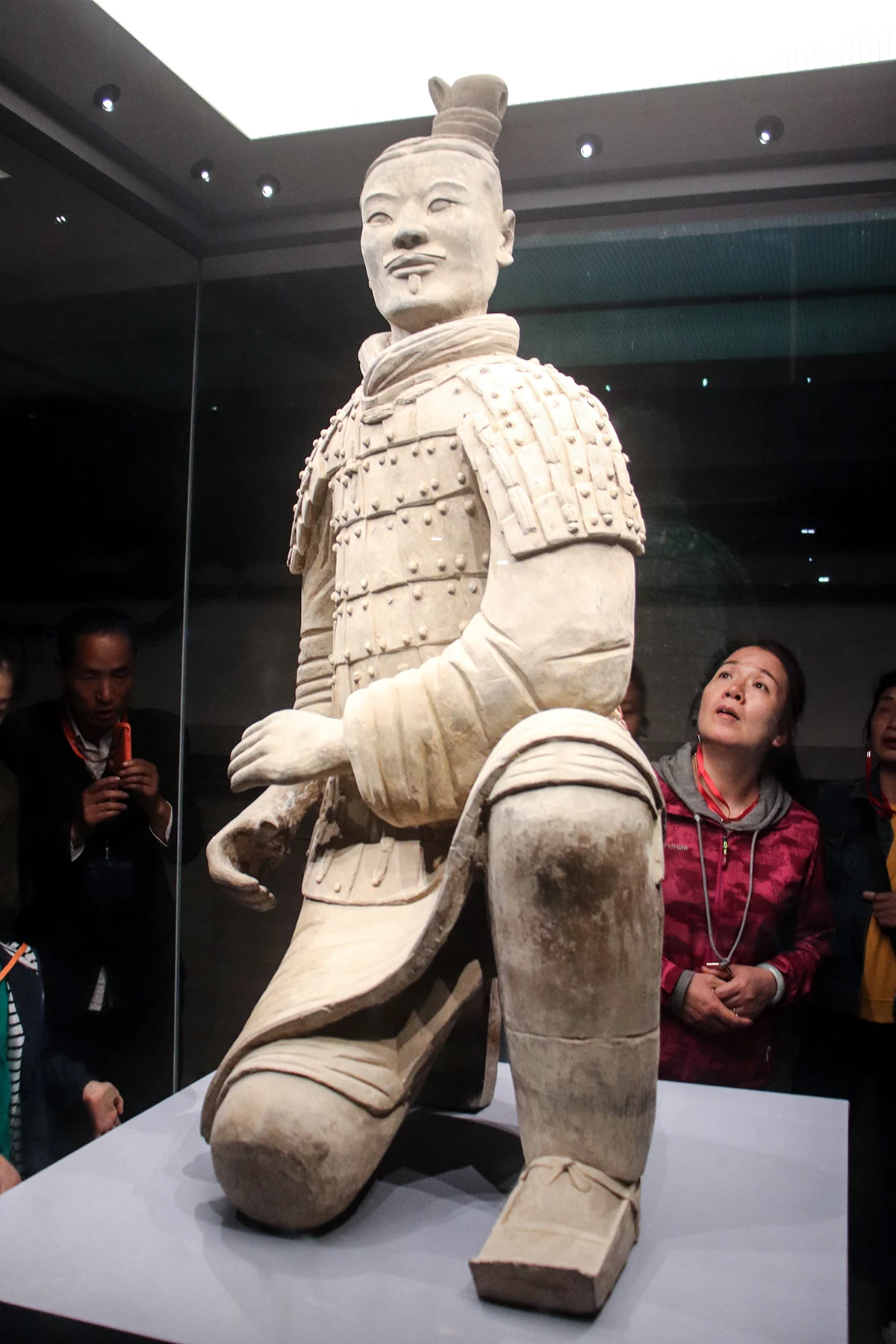 A kneeling terracotta archer in a display case